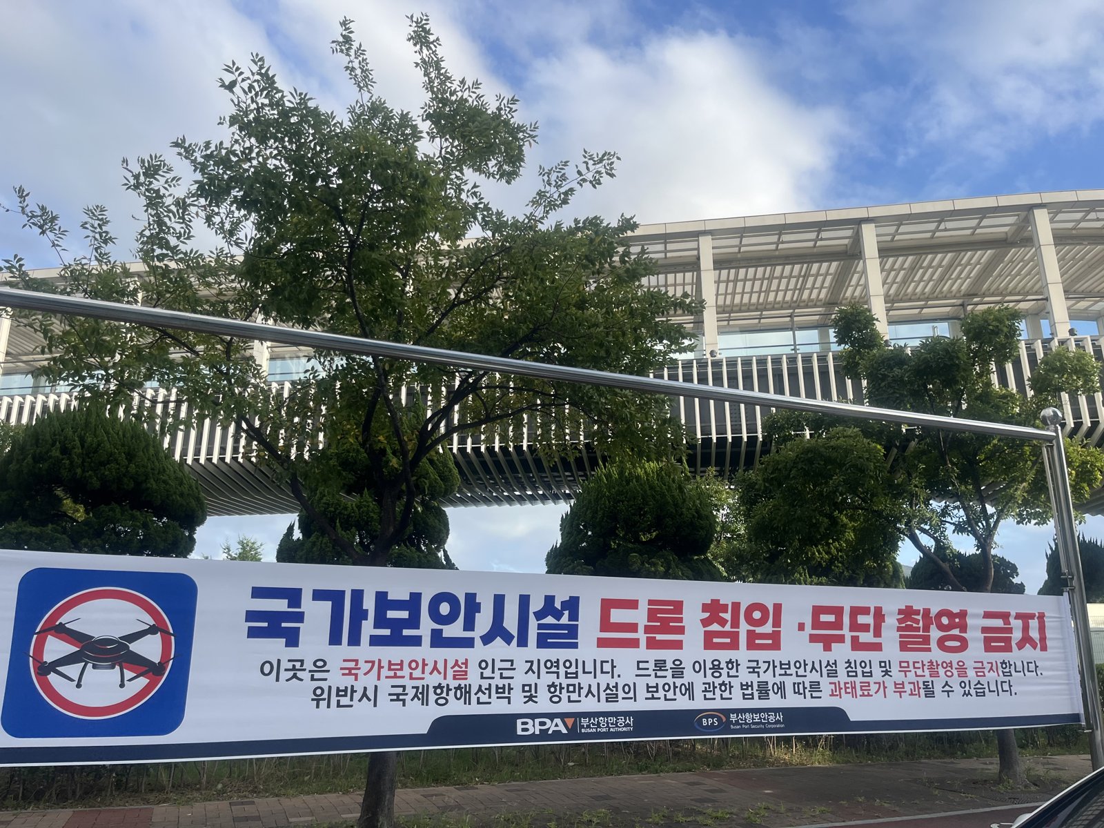부산항국제여객터미널 야외주차장 난간에 「국가보안시설 드론 침입·무단 촬영 금지」라고 적힌 가로 현수막이 걸려 있는 모습