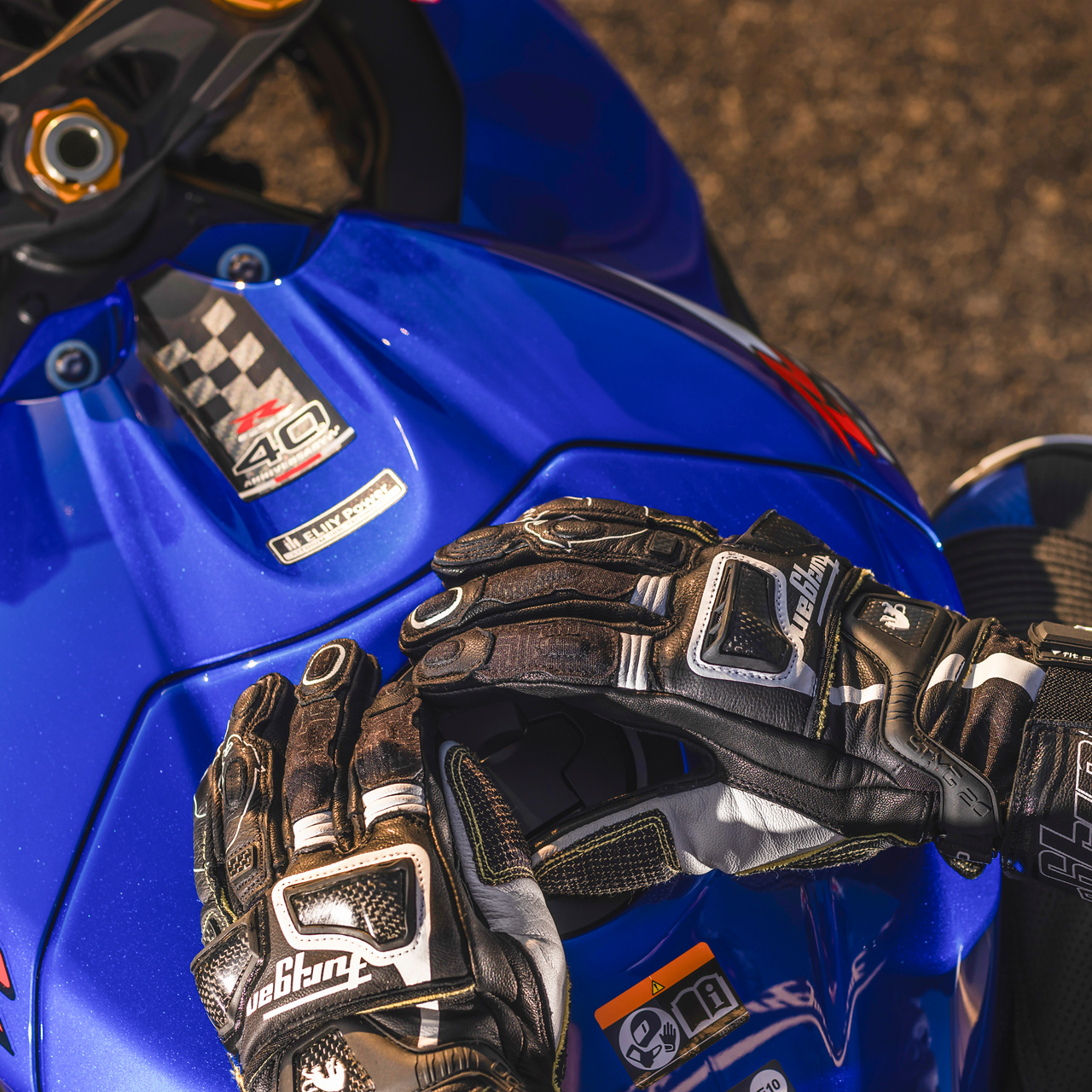 연료탱크 위에 손을 올린 라이더와 GSX-R1000R의 슬림한 16L 연료탱크