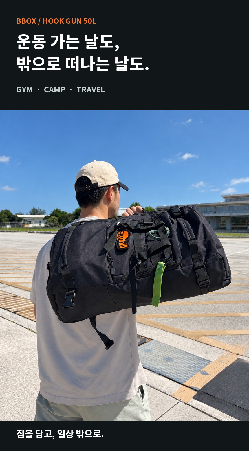 후크건 50L. 운동 가는 날도, 밖으로 떠나는 날도. 베이지 모자와 회색 티셔츠 차림의 남성 모델이 야외에서 가방을 어깨에 들어 보이는 착용 이미지.