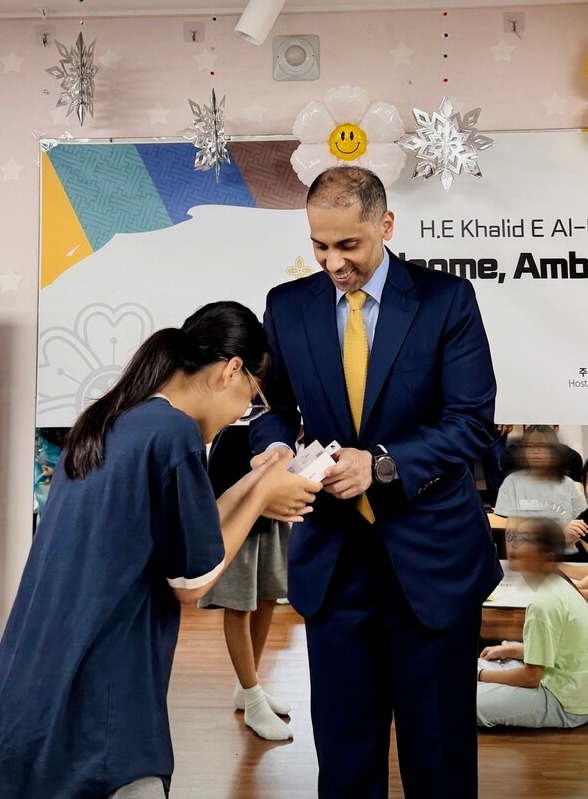 주한 카타르 대사가 아동에게 선물을 전달하며 격려의 메시지를 전하고 있다.
