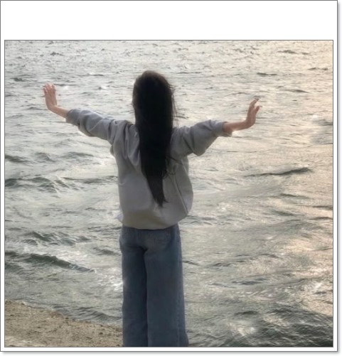 바닷가 앞에서 양팔을 벌려 힐링하는 모습