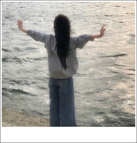 바닷가 앞에서 양팔을 벌려 힐링하는 모습
