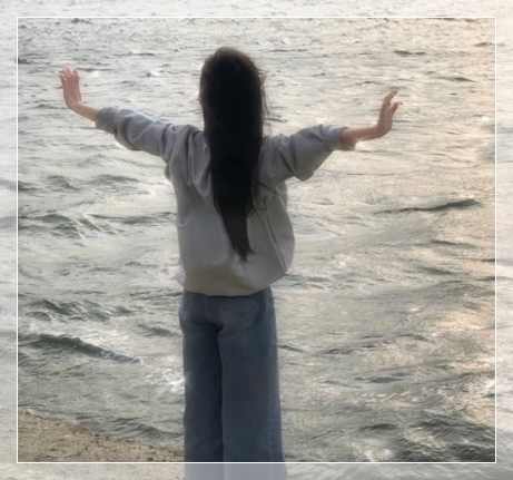 바닷가 앞에서 양팔을 벌려 힐링하는 모습