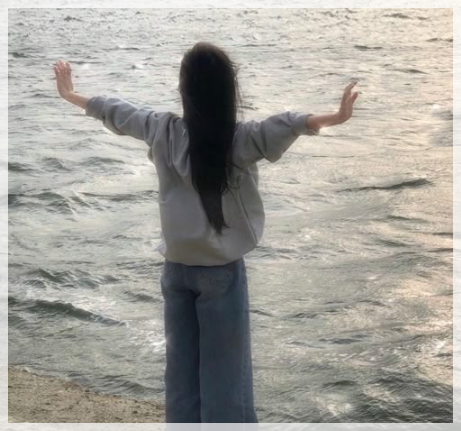 바닷가 앞에서 양팔을 벌려 힐링하는 모습