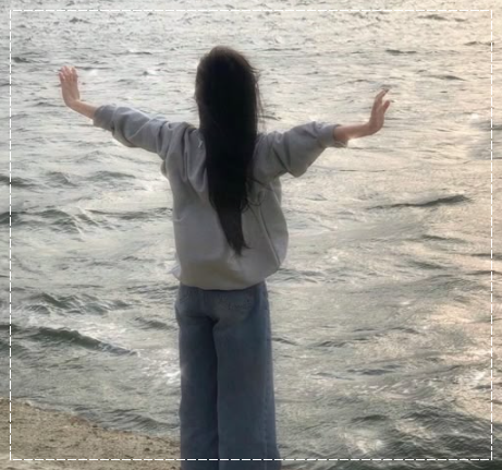 바닷가 앞에서 양팔을 벌려 힐링하는 모습