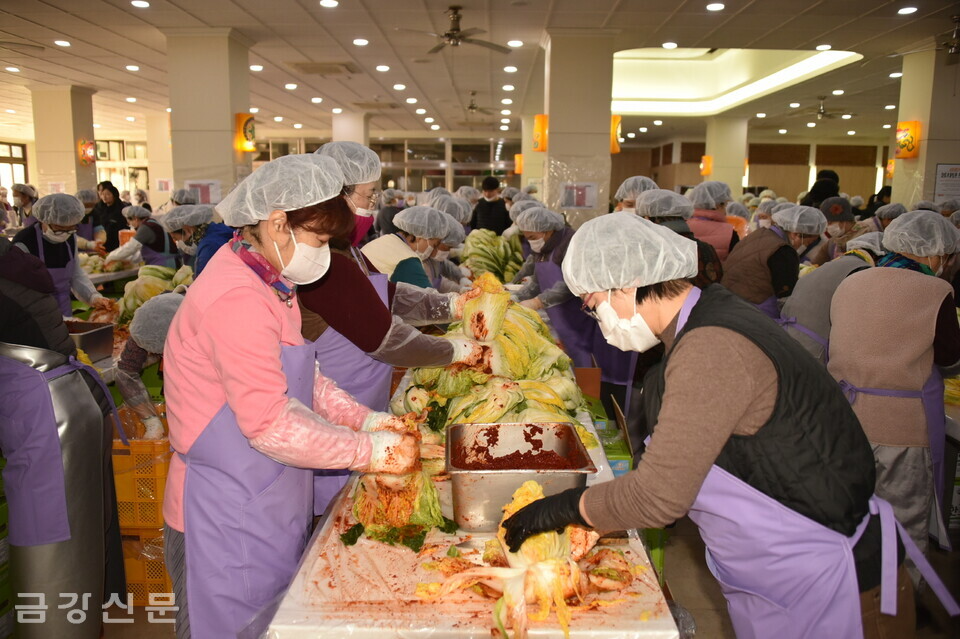 자원봉사자들이 절인 배추에 양념을 버무리고 있다.