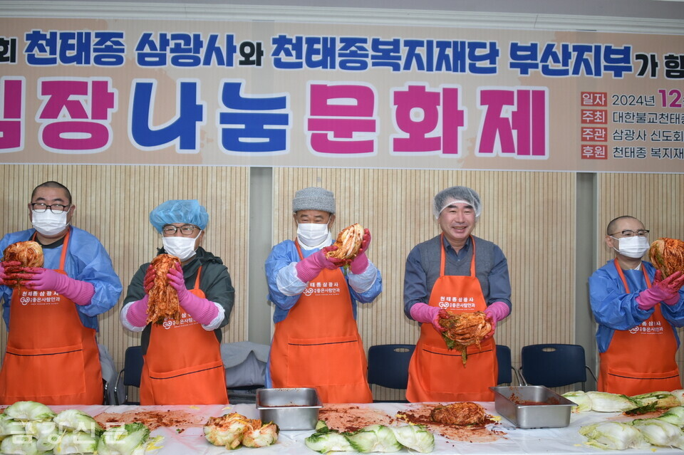 삼광사 주지 영제 스님과 교무 덕중 스님, 천태종복지재단 사무총장 자운 스님,  김영욱 부산진구청장 등이 양념에 버무린  김장김치를 들어 보이고 있다.