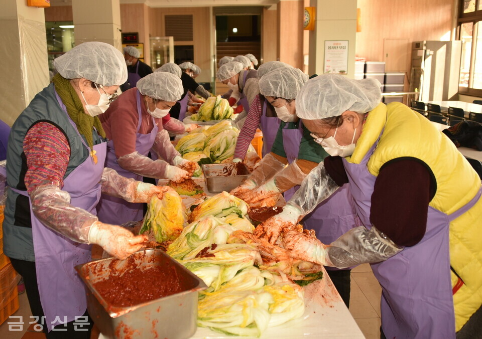 자원봉사자들이 절인 배추에 양념을 버무리고 있다.