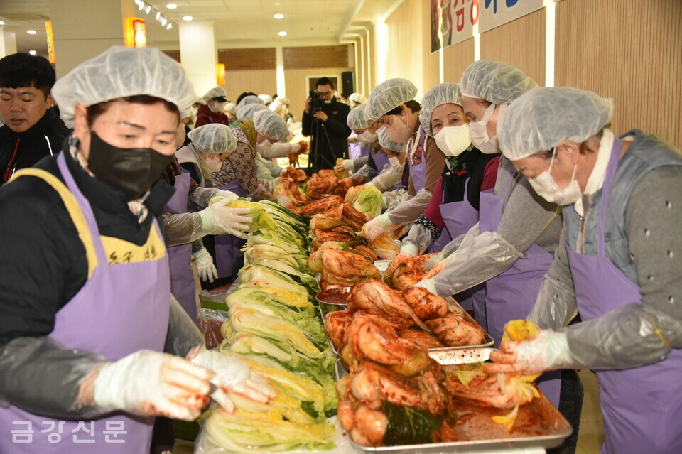 자원봉사자들이 절인 배추에 양념을 버무리고 있다.