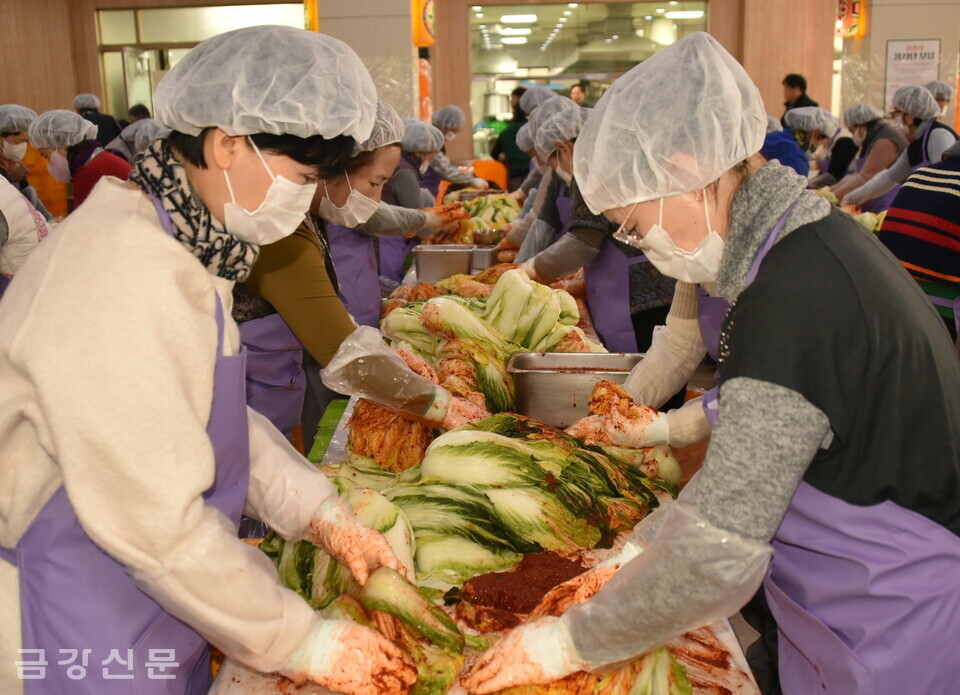 자원봉사자들이 절인 배추에 양념을 버무리고 있다.
