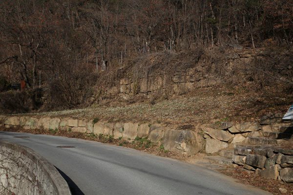 석탑 아래 마을로 들어가는 길, 계곡 위로 도로가 있고 도로의 오른쪽에는 사자빈신사에서 나온 돌들로 축대를 쌓았다.