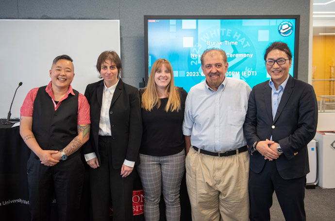 MET Senior Associate Dean for Academic Affairs Lou Chitkushev (ENG’96), and MET Professor of the Practice and Director of Cybercrime Investigation & Cybersecurity Programs Kyung-Shick Choi (MET’02) pose with participants at the 2023 White Hat Conference