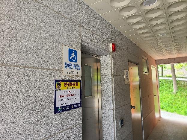 "장애인 화장실 입구 벽면에 부착된 여성안심 비상벨 단말기 근접 촬영