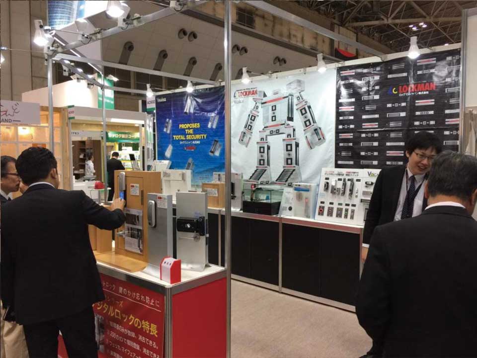 도쿄 건축건자재전 록맨재팬 부스에서 디지털도어록을 살펴보는 참관객 | Visitors viewing digital door lock products at the Lockman Japan booth during the Tokyo Architecture & Building Materials Exhibition