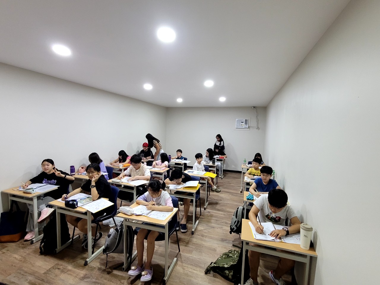 각자의 책상에서 교재와 학습지를 보는 학생들