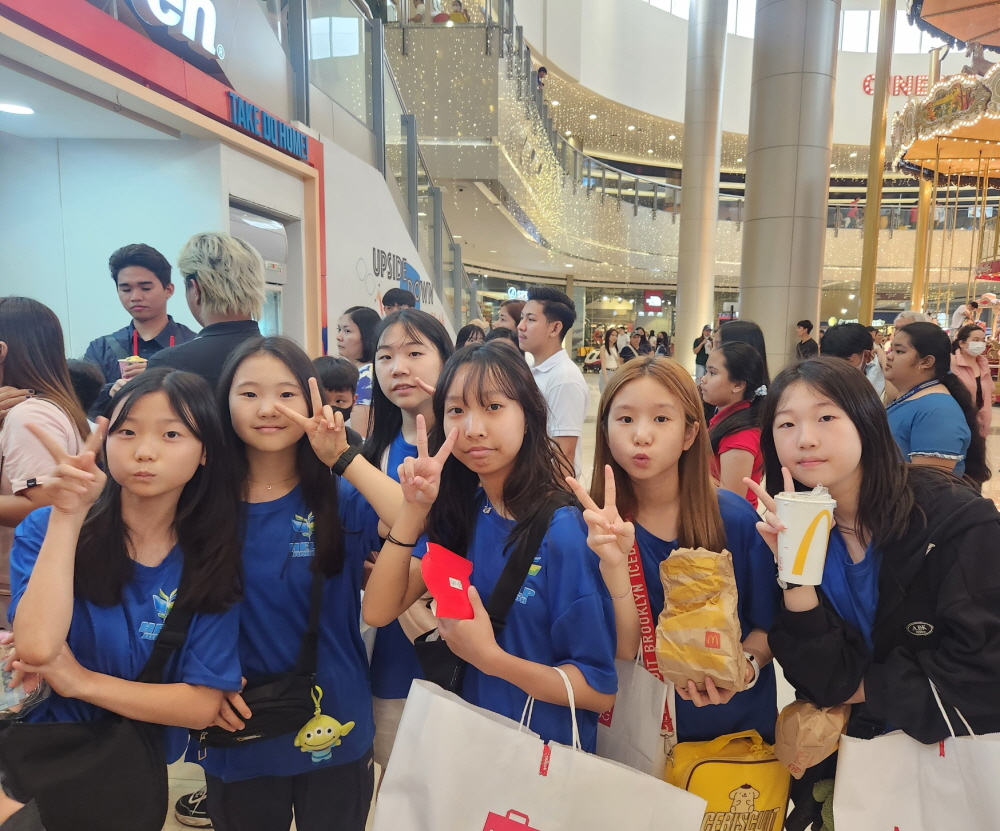 쇼핑몰 안에서 간식과 음료를 들고 모여 있는 학생들