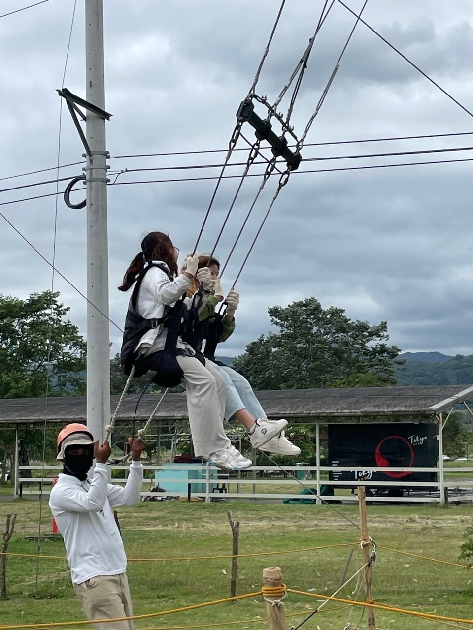 안전 장비를 착용한 채 공중 체험 시설에 앉아 있는 참가자