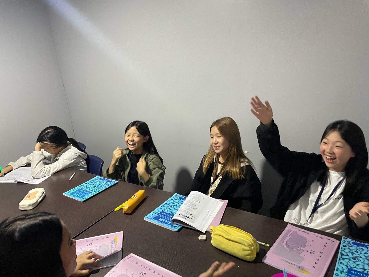 그룹 수업 중 손을 들고 웃는 학생들