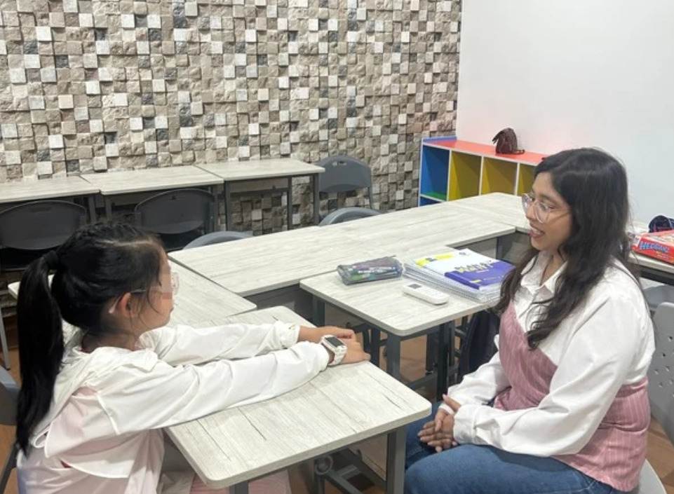 선생님과 학생이 마주 앉아 진행하는 Half 일대일 수업