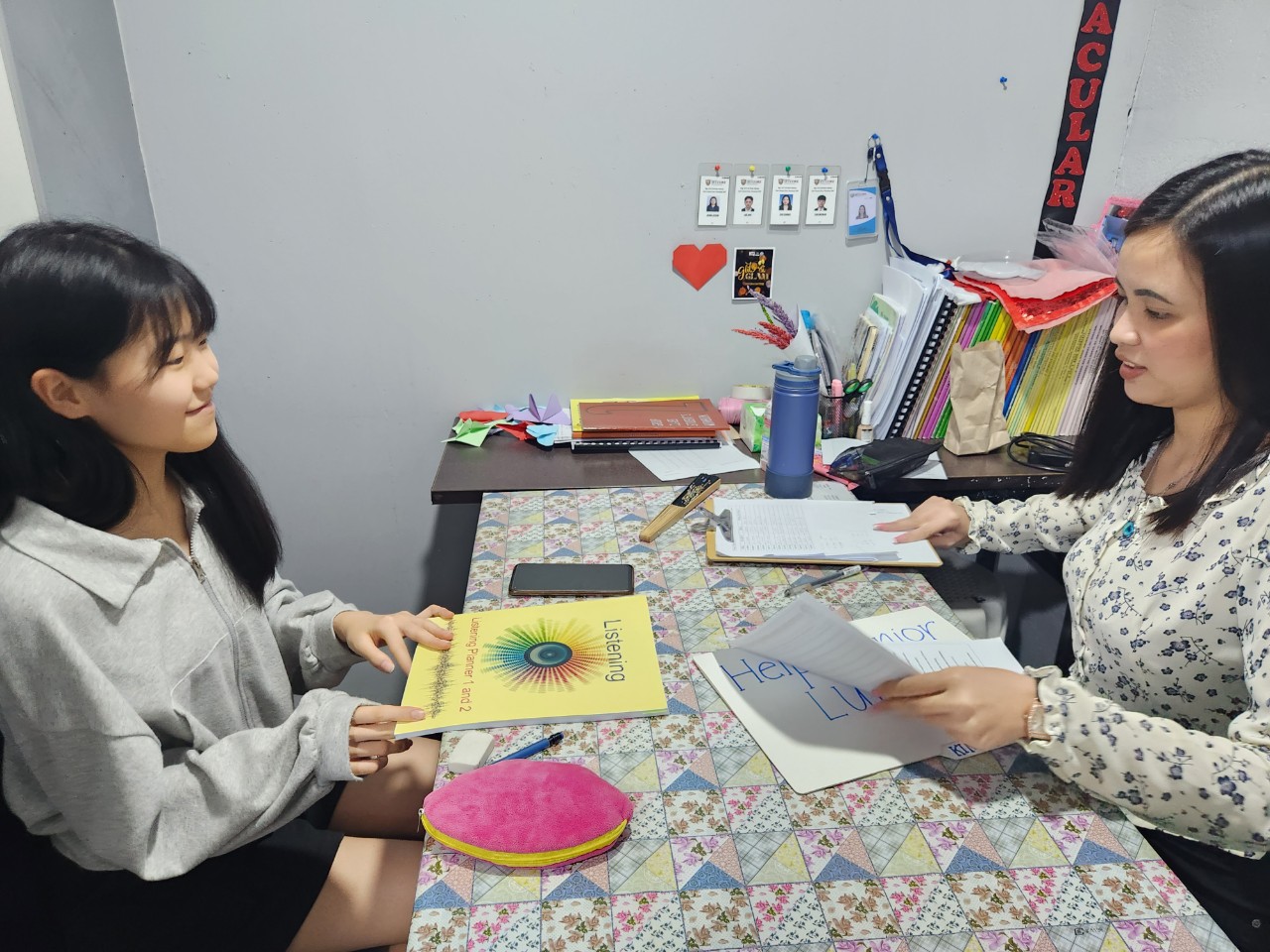 그림이 있는 교재로 대화하는 학생과 강사
