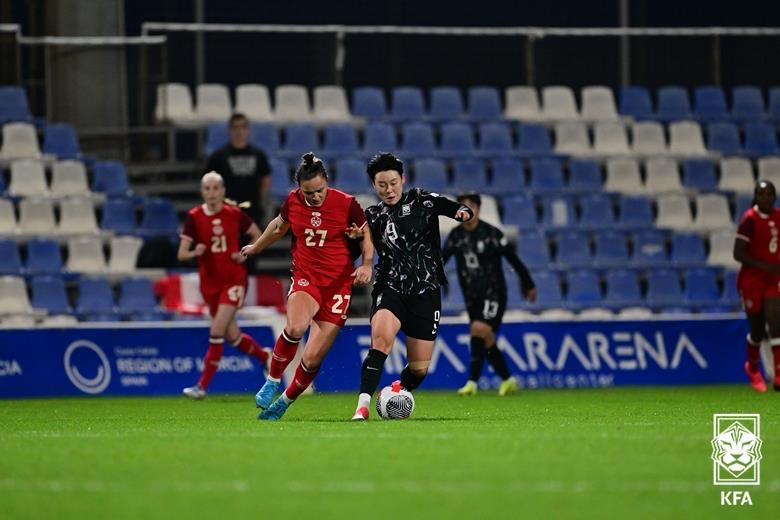 경합하는 캐나다와 한국 여자축구 선수들