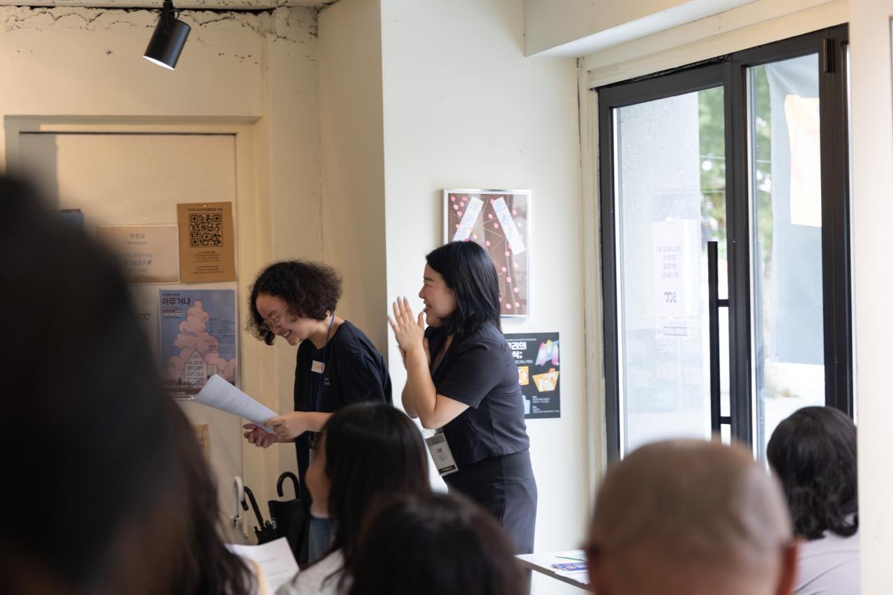 활동가 지혜와 유경이 발표를 들으며 활짝 웃고 있다.