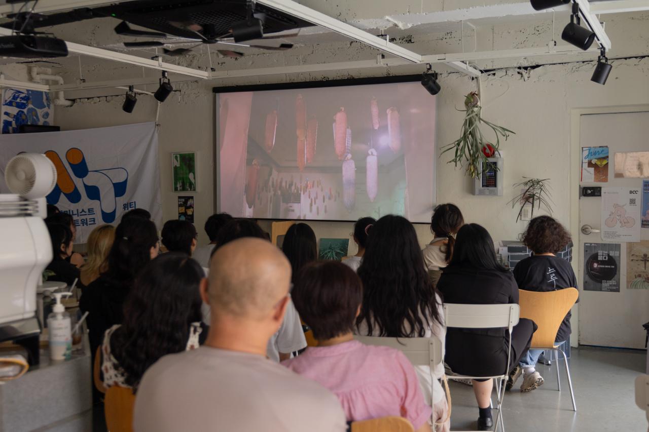 다큐멘터리를 보는 참가자들의 뒷모습