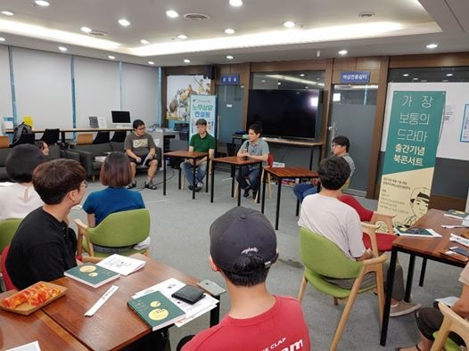 이미지: 사람 2명, 사람들이 앉아 있는 중