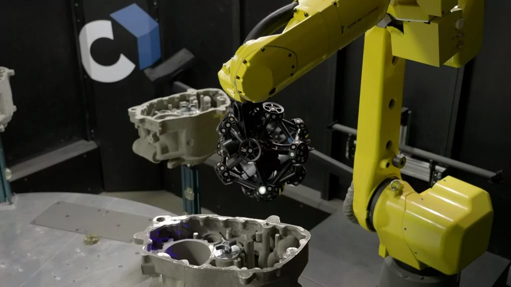 Close up of the robot mounted MetraSCAN-R BLACKΙElite HD scanning six castings on a turntable in a Cube-R