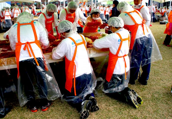 무릎을 꿇고 김장을 담그는 열정의 두산인프라코어 임직원