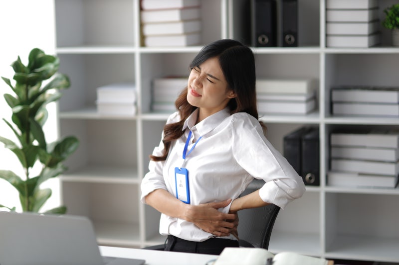 퇴근 후 허리 통증을 겪는 직장인 모습