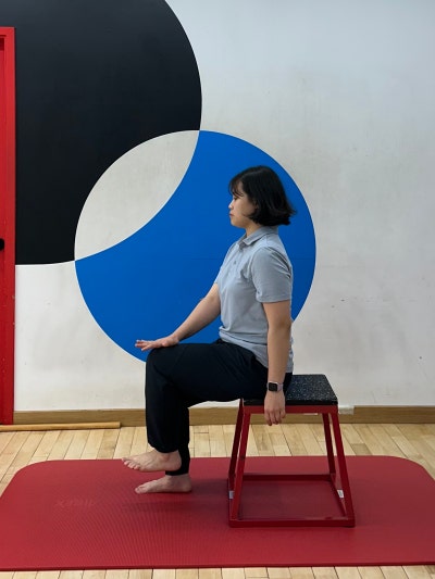 앉은 자세에서 무릎을 들어 올리며 저항을 주는 셀프 체크 동작