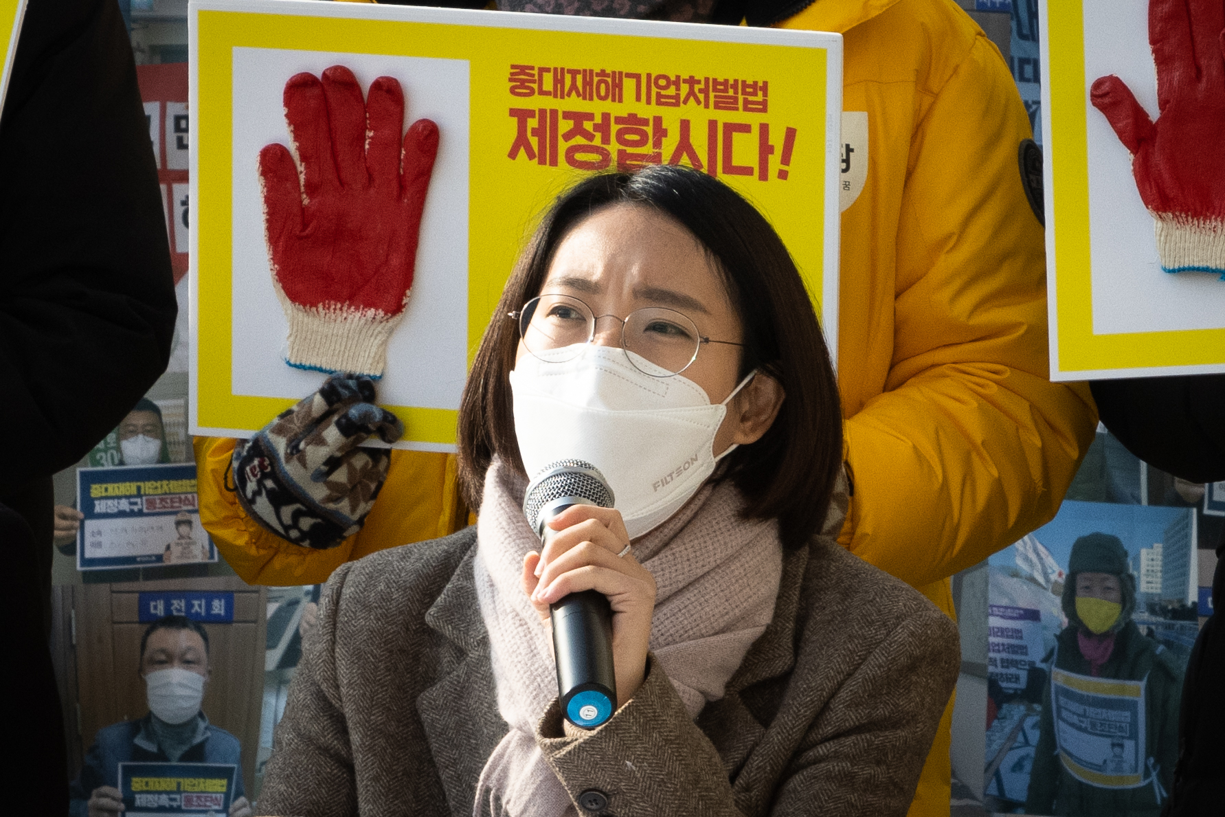 발언하고 있는 장혜영 의원의 사진. 그의 뒤에는 작업용 목장갑을 붙인 "중대재해기업처벌법 제정합시다!" 손피켓이 보인다.