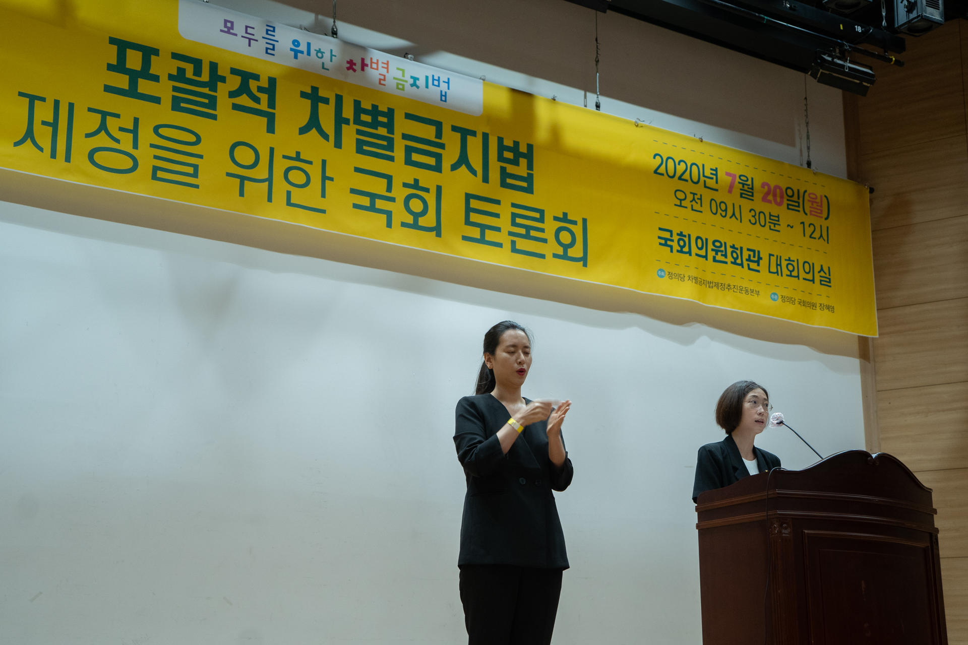 포괄적 차별금지법 제정을 위한 국회 토론회에서 환영사를 하고 있는 장혜영 의원과 수어통역사의 사진입니다.