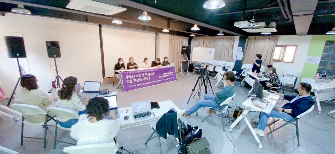 5명의 활동가가 보고회를 진행하고 있고, 7명의 사람들이 보고회를 지켜보고 있다. 일부는 카메라로 보고회를 촬영중이다.