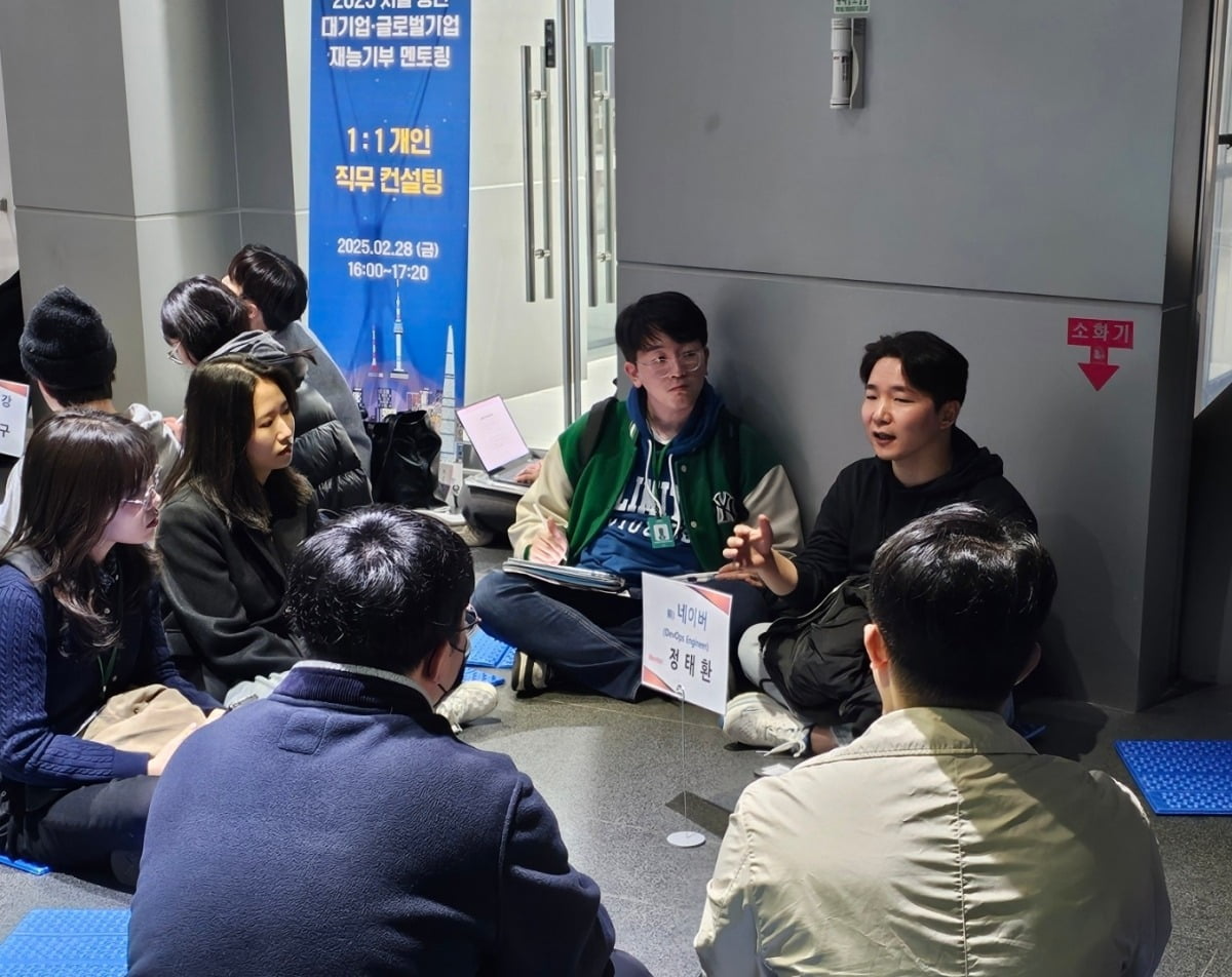 서울시청 다목적홀 2층 복도에서 청년들이 바닥에 돗자리를 깔고 앉아 정태환 네이버 전 개발자와 대화를 나누고 있다. 권용훈 기자