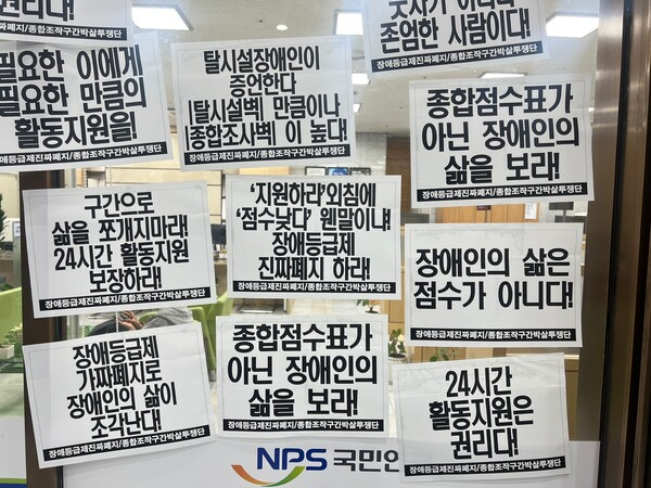 국민연금공단 서울남부지역본부 내부에 ‘24시간 활동지원 보장하라’, ‘장애인의 삶은 점수가 아니다’ 등의 종이가 붙여져 있다.ⓒ전국장애인차별철폐연대
