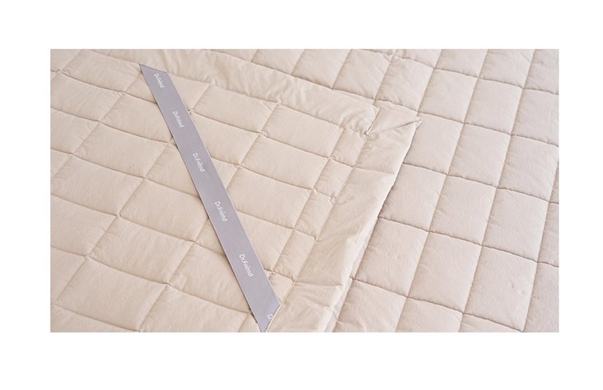 Detailed view of the beige Dr.Friend Sleep Pad fabric showing quilted stitching and soft cotton texture