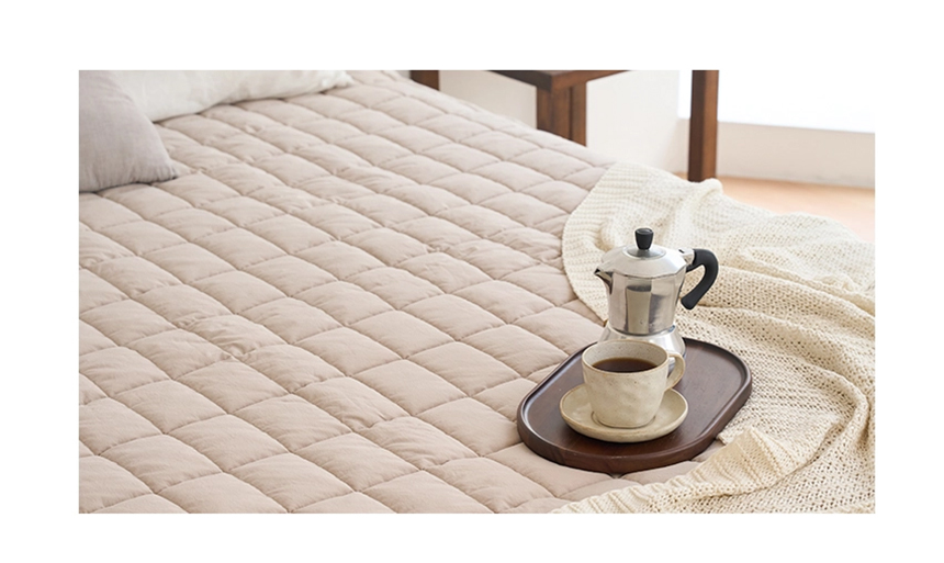 Close-up of a beige Dr.Friend Sleep Pad with a tray and coffee cup, highlighting a relaxed and cozy setting