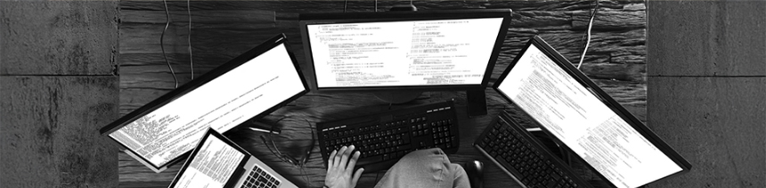 Overhead view of a person working with multiple electronic devices, illustrating intensive daily use of computers and monitors