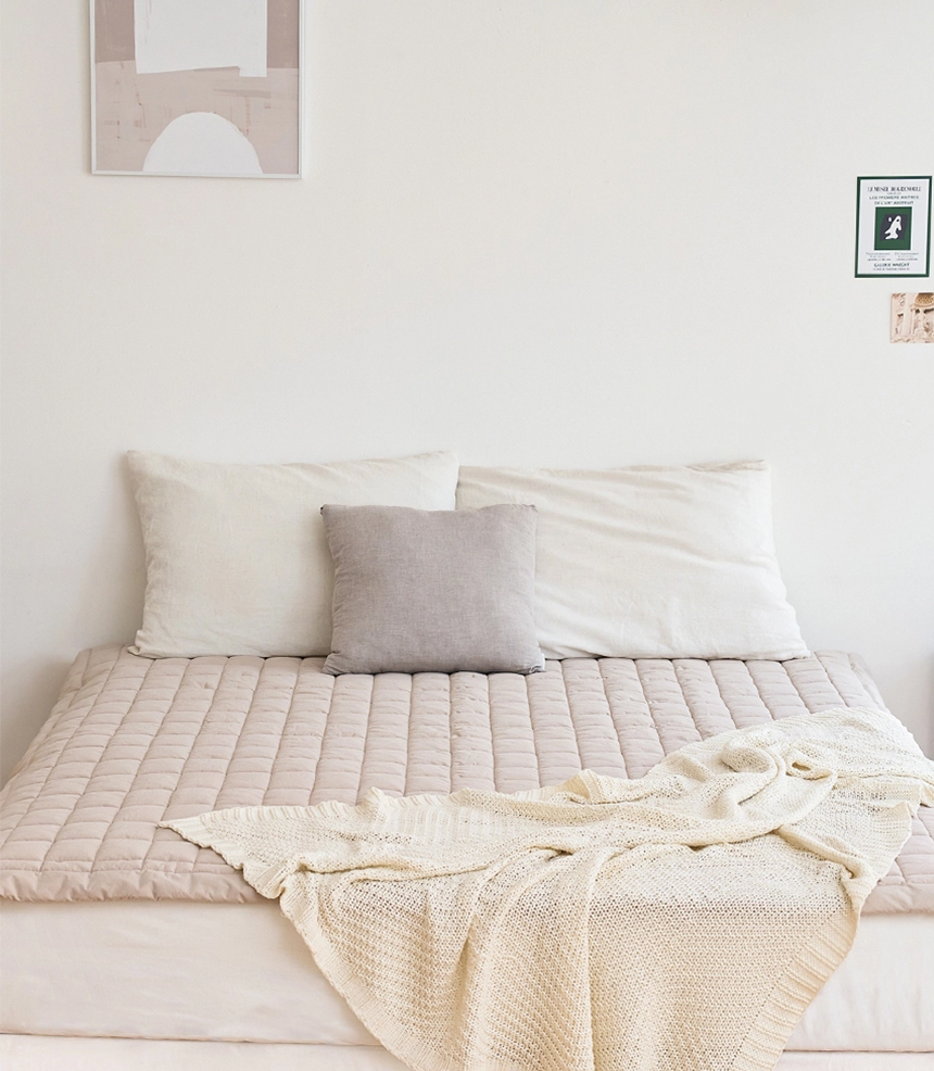Dr.Friend Sleep Pad in beige displayed on a bed, expressing a sophisticated and warm bedroom atmosphere