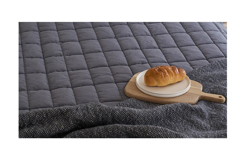 Close-up of a charcoal Dr.Friend Sleep Pad with a tray and bread, highlighting a calm and cozy setting