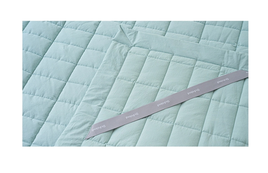 Detailed view of the mint Dr.Friend Sleep Pad fabric showing quilted stitching and smooth cotton texture