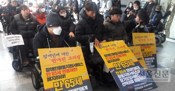 사진은 지난 10일 서울 중구 국가인권위원회 1층 로비에서 열린 전국장애인차별철폐연대 기자회견에서 휠체어를 사용하는 장애인들이 활동지원 제도의 연령 제한을 폐지할 것을 촉구하고 있는 모습. 사진은 지난 10일 서울 중구 국가인권위원회 1층 로비에서 열린 전국장애인차별철폐연대 기자회견에서 휠체어를 사용하는 장애인들이 활동지원 제도의 연령 제한을 폐지할 것을 촉구하고 있는 모습.