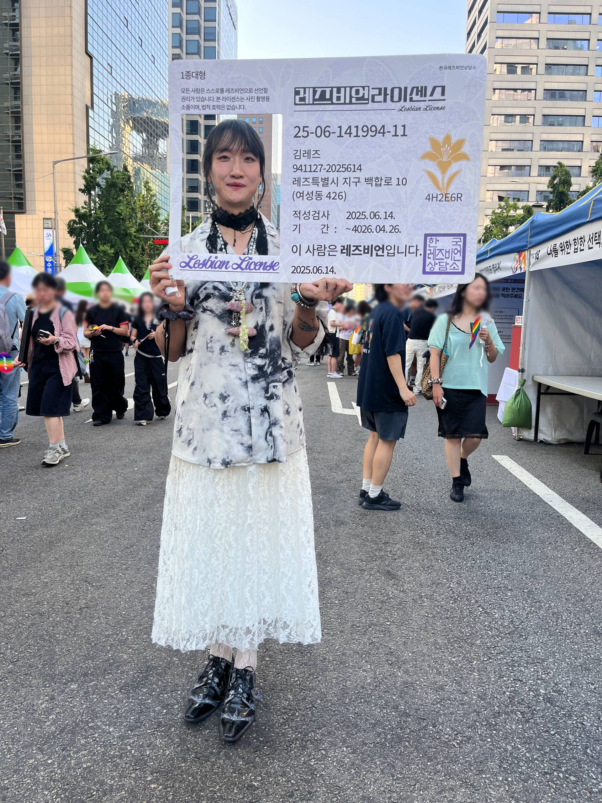 활동가 이로가 한국레즈비언상담소의 '레즈비언라이센스'를 들고 사진을 찍고 있다.