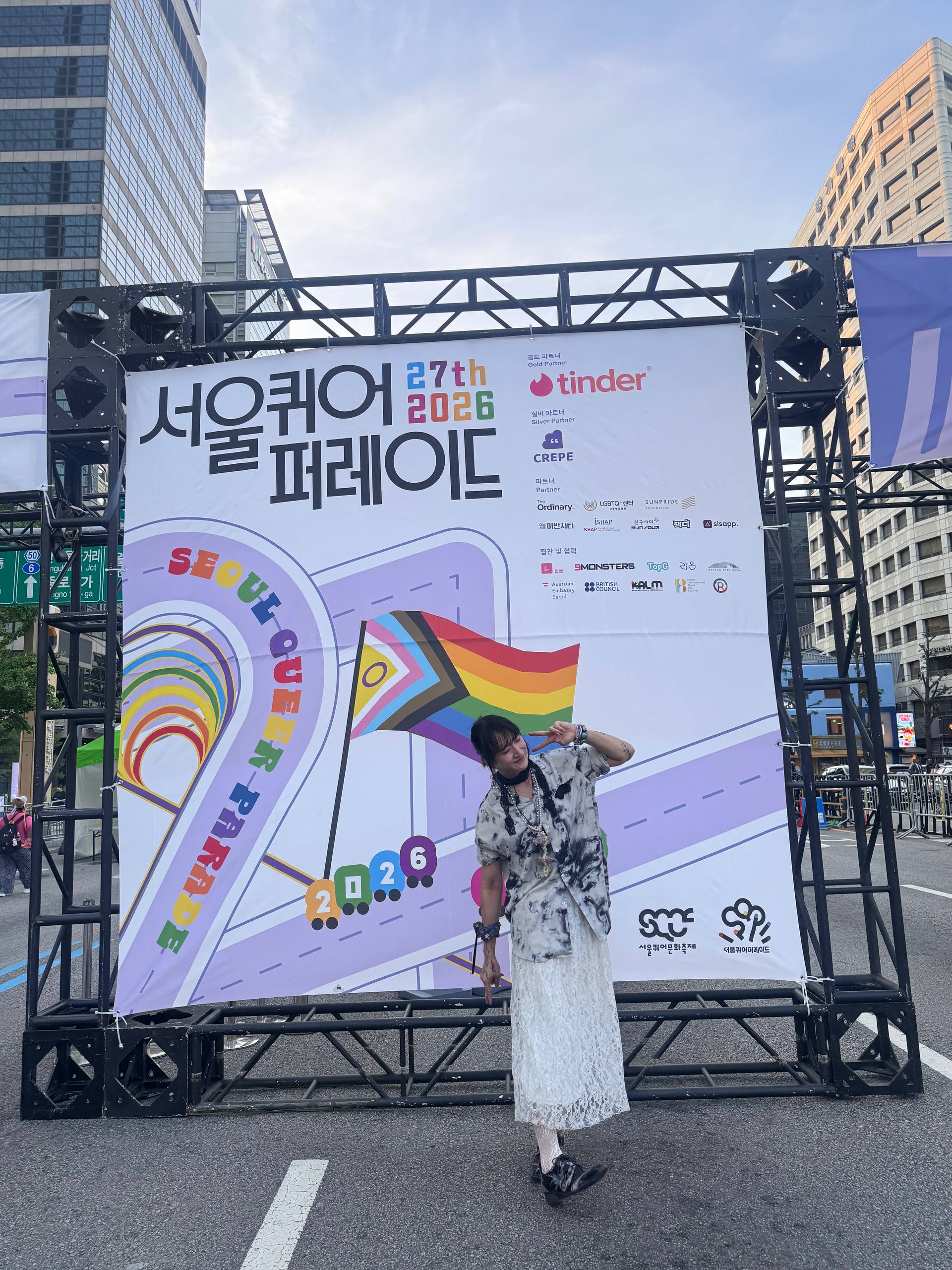 서울퀴어퍼레이드 현장 사진. 포토존 앞에서 활동가 이로가 포즈를 취하고 있다