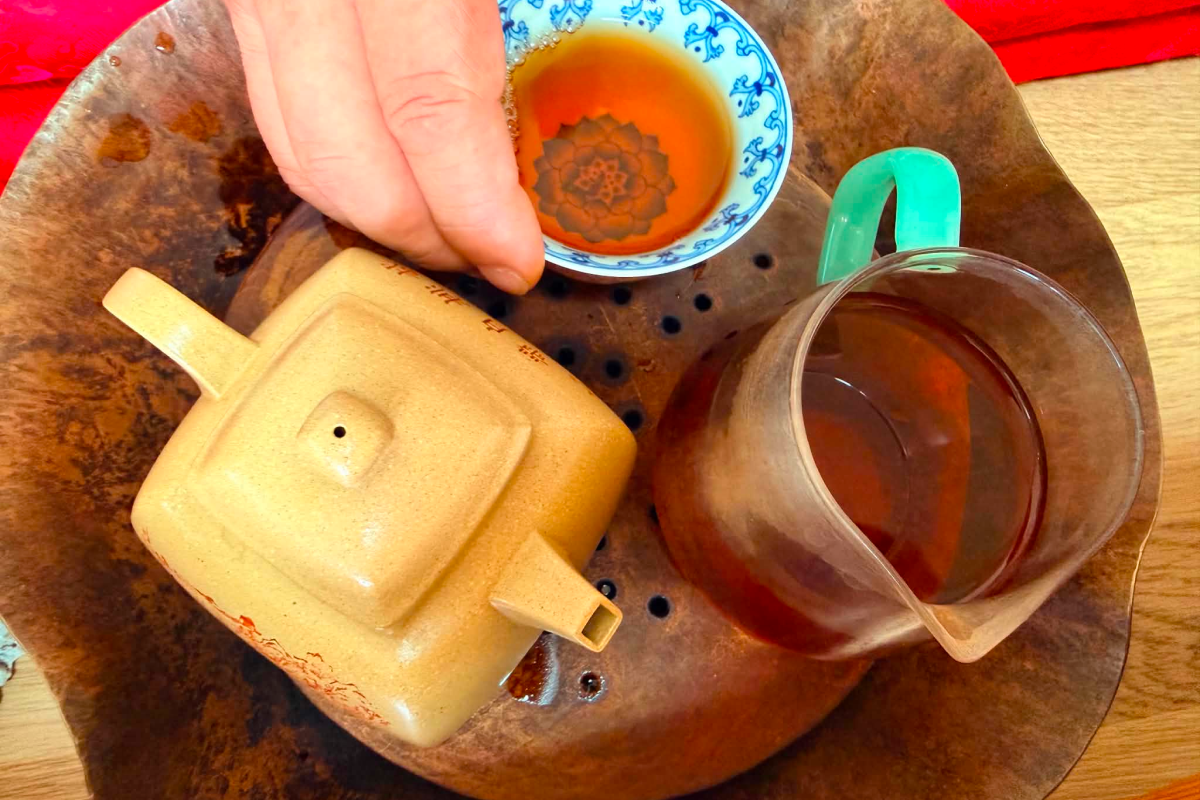 A pure and minimal tea setup neatly arranged on a wooden table inside the temple