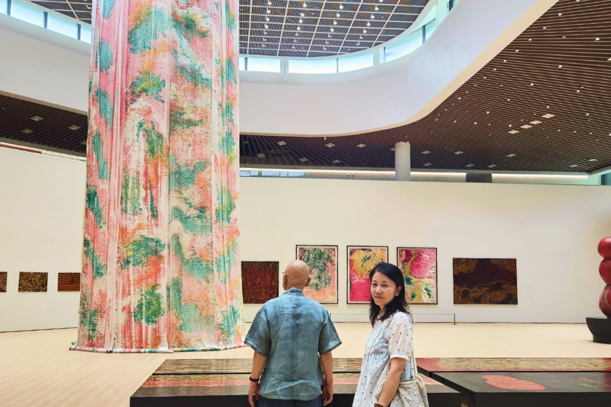 Master Seongpa and CEO Park Hyun-jung standing in front of a monumental art installation at Tongdosa
