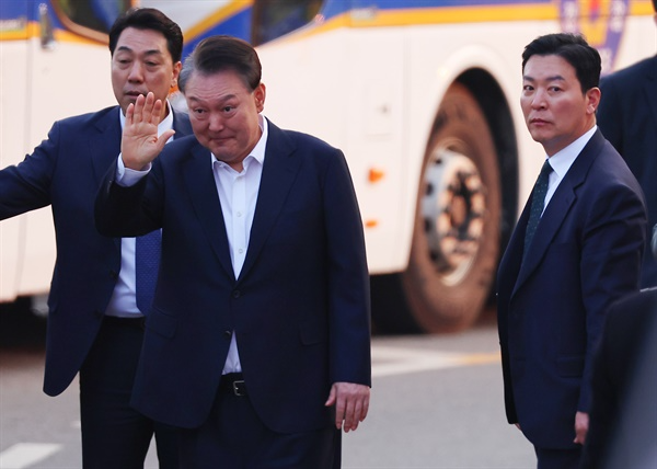  윤석열 대통령이 3월 8일 경기도 의왕시 서울구치소 앞에서 경호차량에서 내려 지지자들에게 인사하고 있다. 그 옆으로는 김성훈 경호처 차장(오른쪽)이 윤 대통령을 경호하며 이동하고 있다.