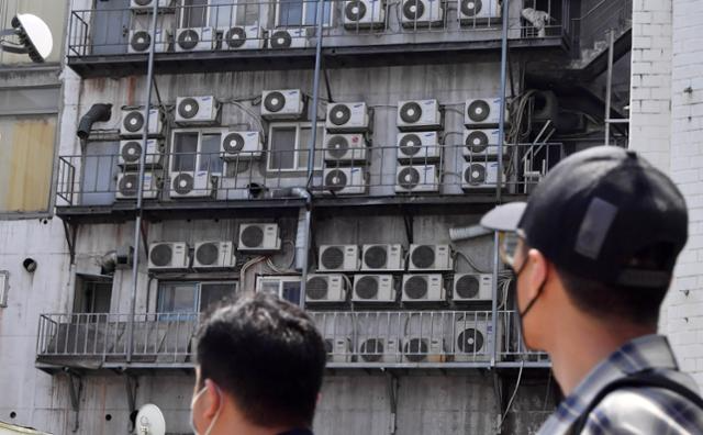 본격적인 여름이 시작되면서 전력 사용량이 크게 늘어나고 있다. 사진은 2021년 7월 서울의 한 건물 외벽에 설치된 에어컨 실외기가 열기를 내뿜는 모습. 서재훈 기자